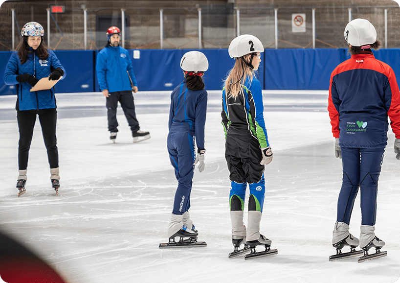 A group of people on skating equipment in the snow.