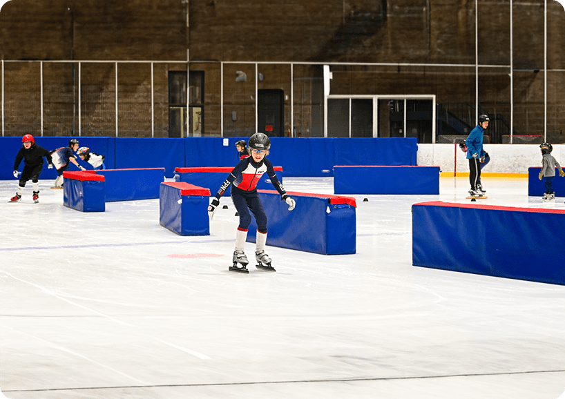 A person on a skateboard in an indoor skate park.