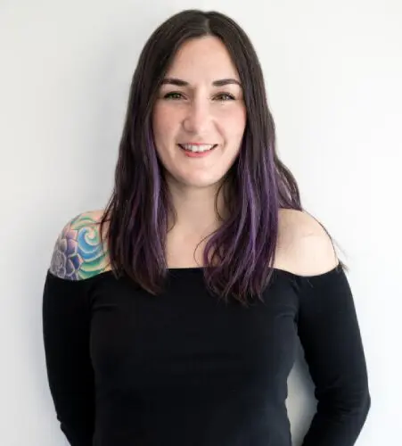 A woman with purple hair and black shirt