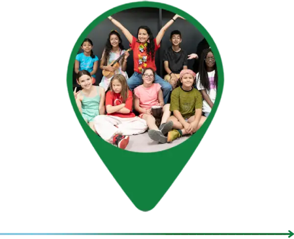 A group of people sitting in front of a green map pin.